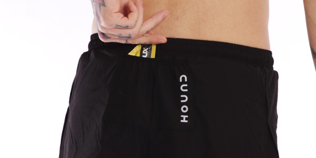 Homem tirando gel de carboidrato do shorts split da Hound
