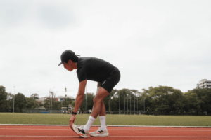 Homem se alongando na pista de corridaa