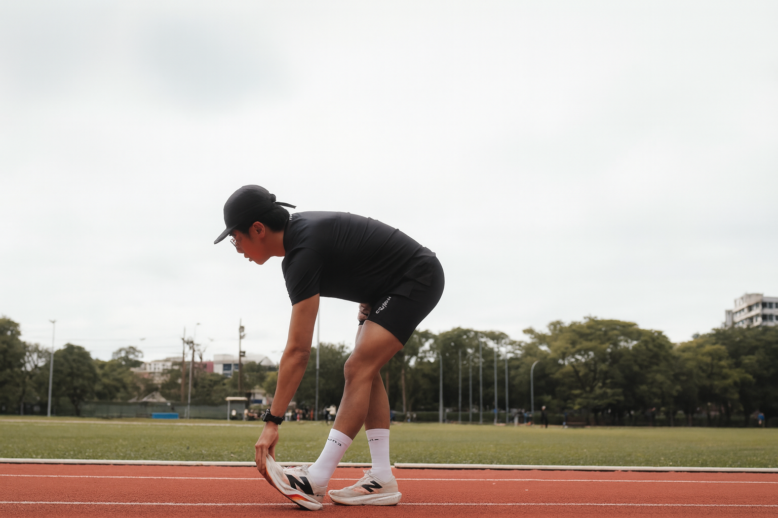 Homem se alongando na pista de corridaa