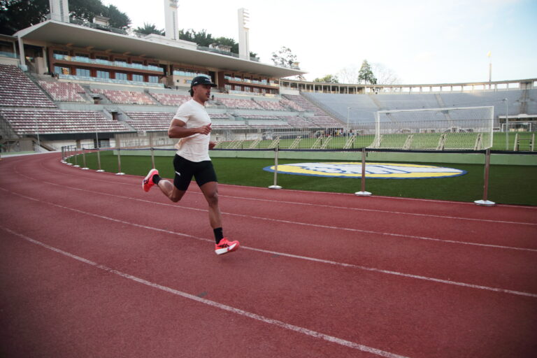 homem correndo em pista de atletismo