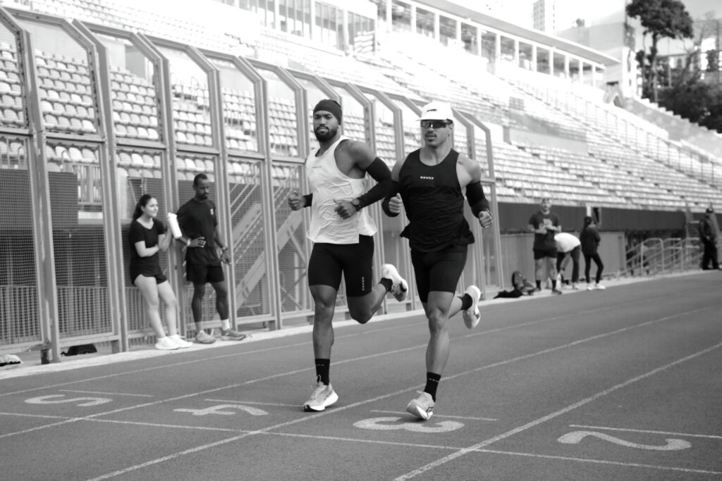 HOMENS CORRENDO EM PISTA DE ATLETISMO