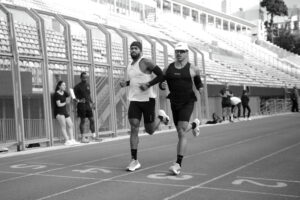 HOMENS CORRENDO EM PISTA DE ATLETISMO
