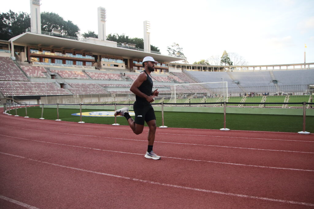 homem correndo em pista de atletismo