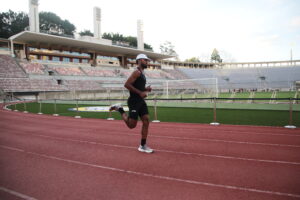 homem correndo em pista de atletismo